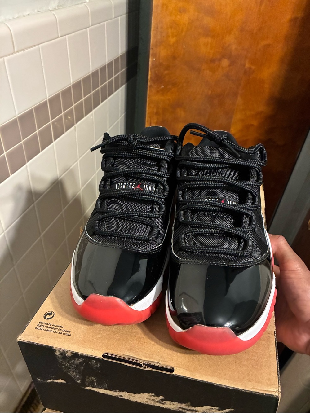 Jordan 11 Black Patent Leather Low-Top Sneakers with Red Soles